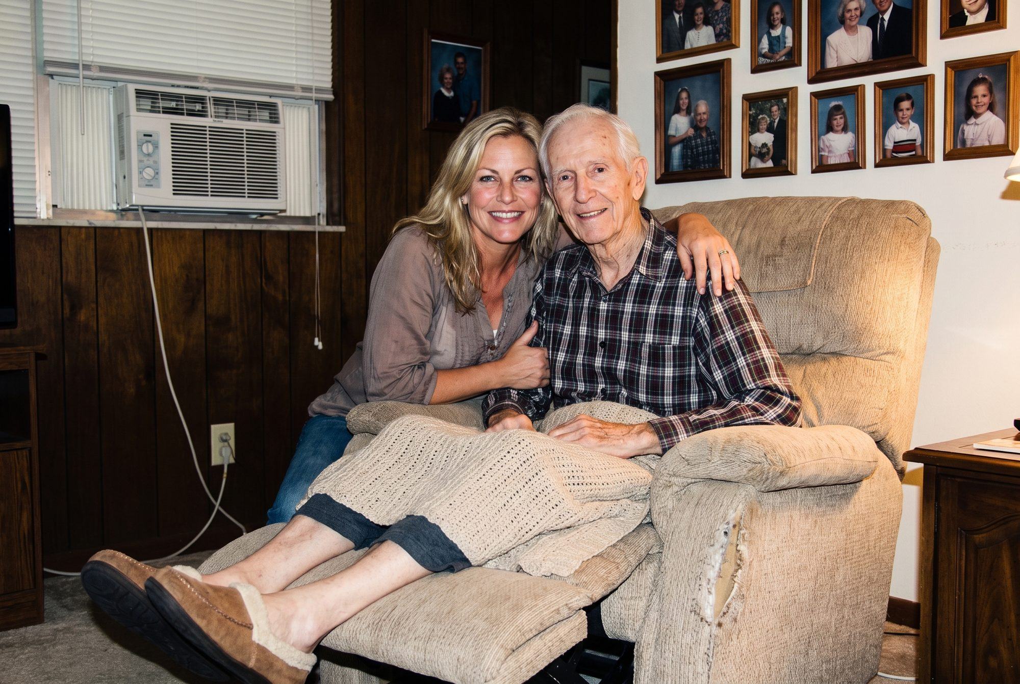 A 2013 snapshot of a younger Dana Whitfield beside her father in his recliner, in the wood panelled living room of his house in Florida Shores